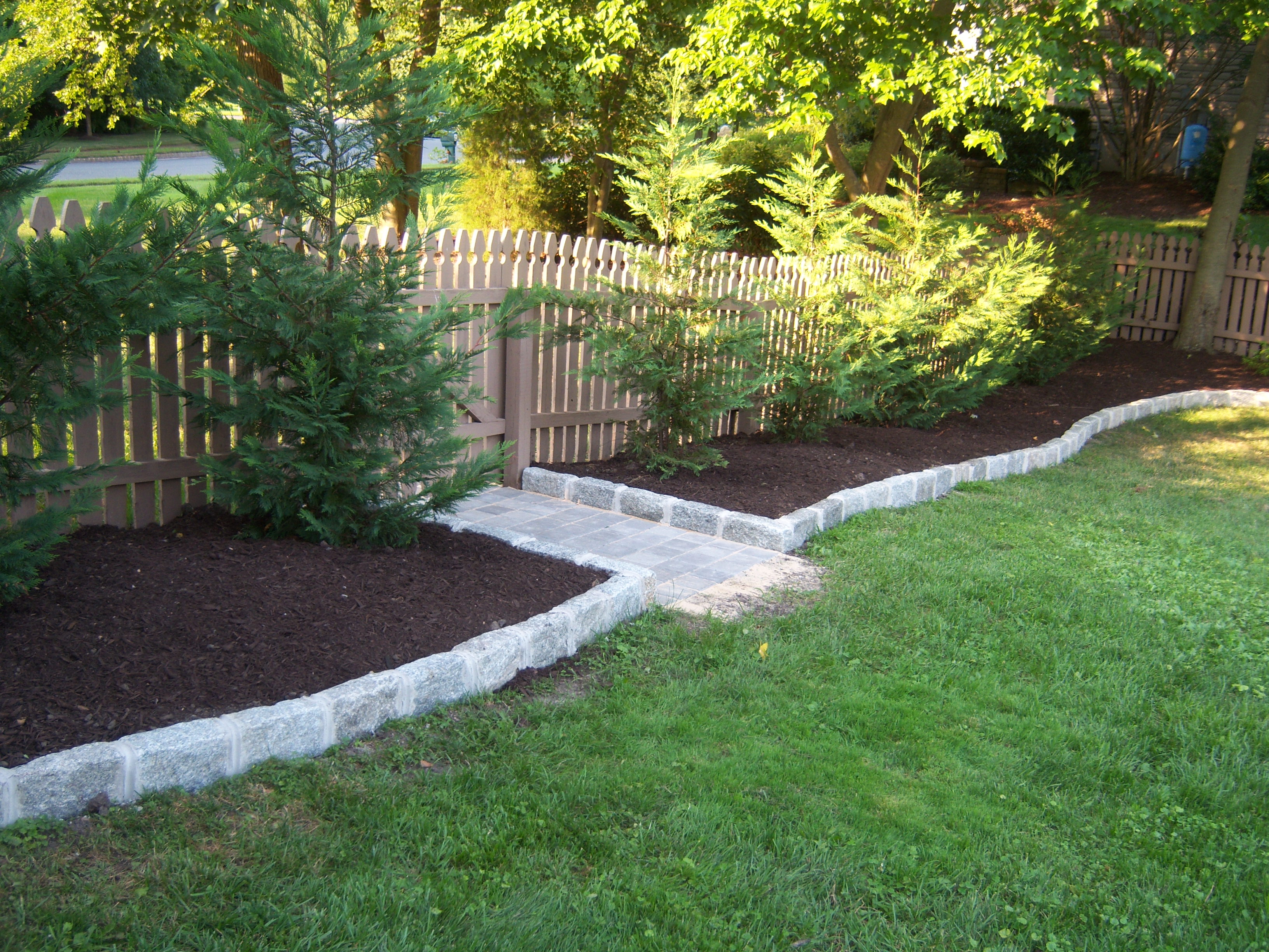 Backyard Mulch with Leyland Cypress and Belgian Block